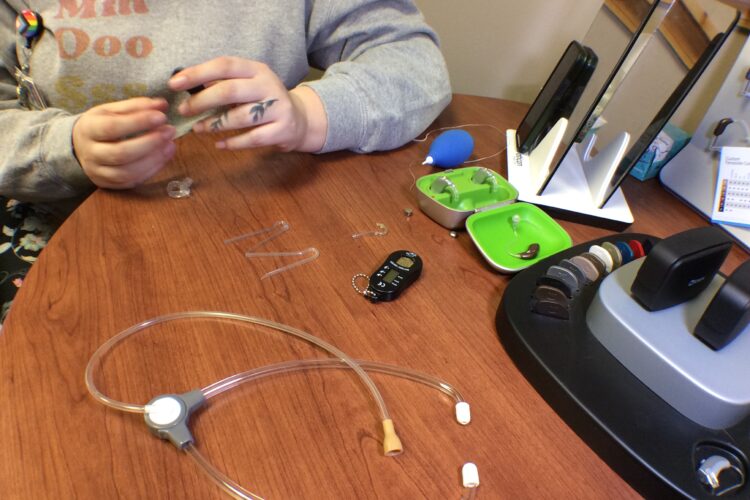 Pieces of a hearing aid, scattered across a tabletop